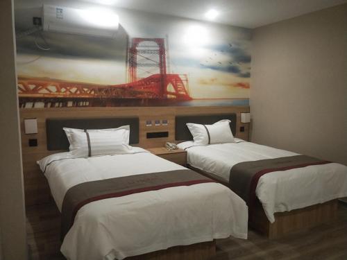 徐州尚客优酒店江苏徐州鼓楼区金桥路店的两张位于酒店客房的床,墙上挂着一幅画