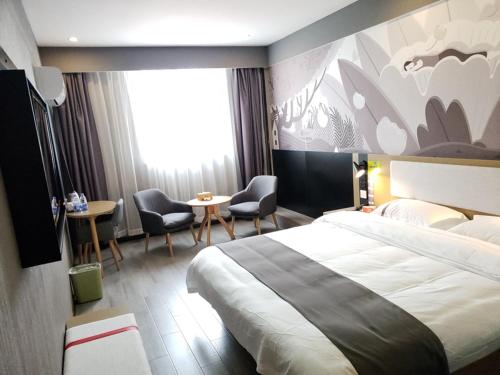 安庆尚客优酒店安徽安庆宜秀区政府大学城店的酒店客房带一张大床和椅子