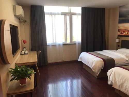 南京尚客优酒店江苏南京江宁区陶吴店的酒店客房设有两张床和窗户。