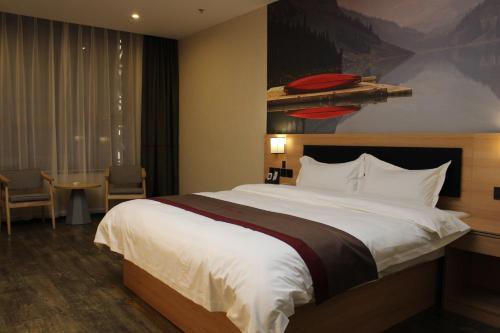 Kaiba尚客优酒店青海海西州乌兰县兴海商业街店的酒店客房设有一张大床和一张桌子。