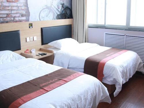 廊坊骏怡连锁河北廊坊广阳区廊坊站店的酒店客房设有两张床和电视。