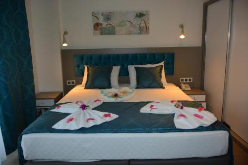 凯麦尔THE NORDİC HOTEL的一间卧室配有一张带两件衣服的床