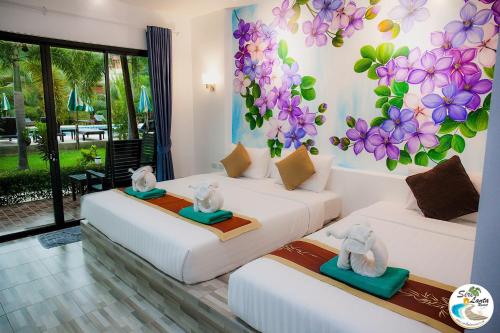高兰Siri Lanta Resort的墙上花房的两张床