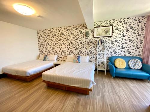 小琉球岛好事好室Goodthings的一间卧室配有两张床和蓝色的沙发