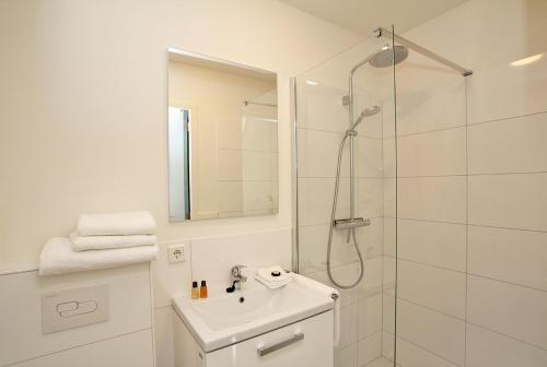 迪温特Citystays Deventer的带淋浴和盥洗盆的白色浴室