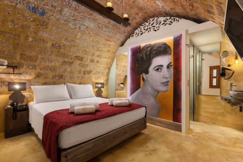罗德镇10GR Boutique Hotel & Wine Bar的卧室配有一张带女性绘画的床