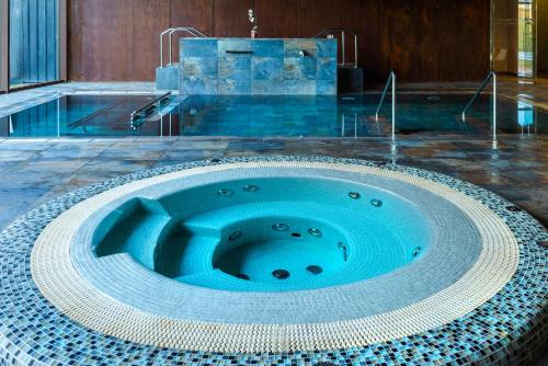 穆里略德加列戈阿瓜德洛斯马娄斯Spa酒店的中间设有蓝色浴缸的游泳池
