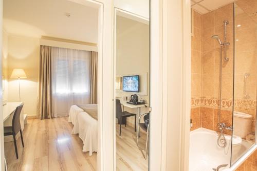 菲格拉斯比利牛斯山酒店的带浴缸的浴室和卧室