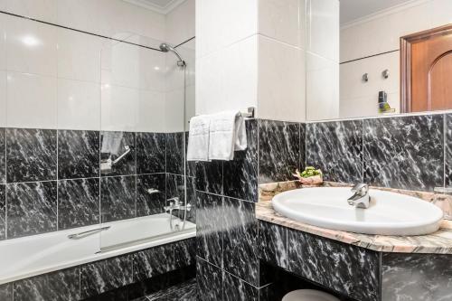 希洪阿尔克玛酒店的浴室配有盥洗盆和浴缸。