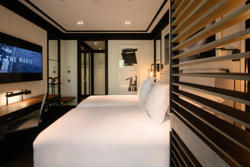 巴塞罗那Seventy Barcelona的一间酒店客房,设有两张床和电视