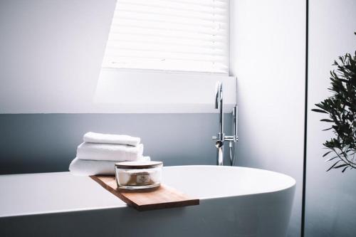 哈尔德韦克B&B Logeren bij Lies的浴室配有白色浴缸和水槽