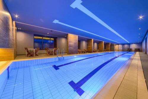 兹拉蒂博尔Kalman SPA&GYM的蓝色灯光的酒店的大型游泳池