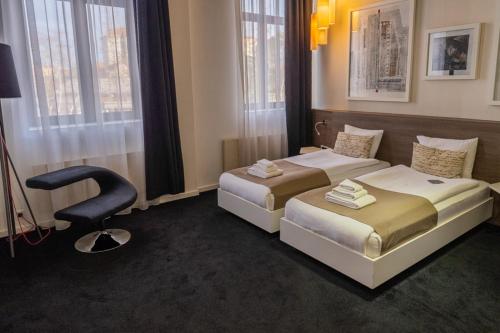 尼什加尔尼一特酒店的酒店客房,配有两张床和椅子
