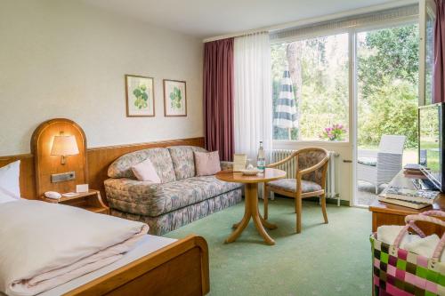 巴特贝林根马库斯霍库酒店的客厅配有沙发和桌子