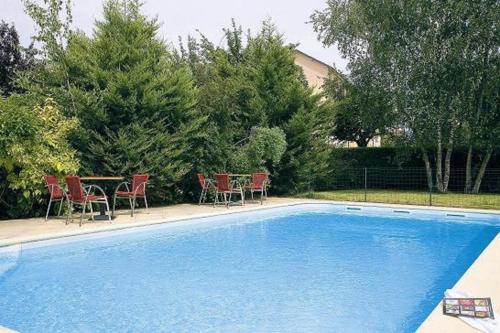 塞尔河畔阿尔帕容省级之家酒店的游泳池配有椅子、桌子和桌椅