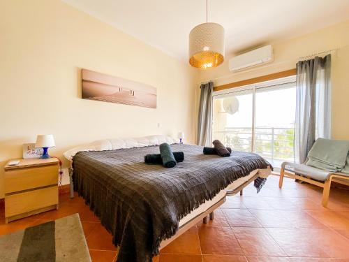 拉戈斯Sea View Apartment by Beach & Marina #1869的卧室配有床、椅子和窗户。