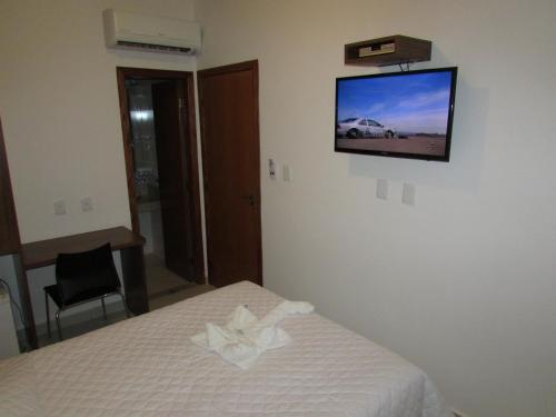 瓦拉达里斯州长市马斯特酒店的卧室配有一张床,墙上配有电视。