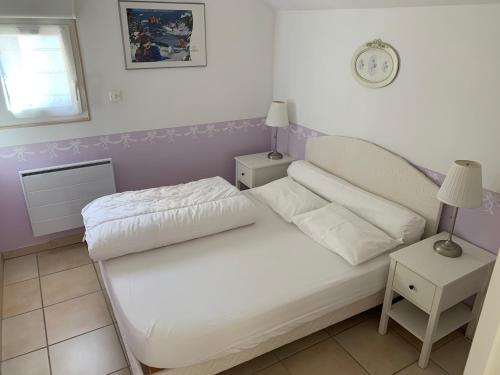 热拉梅Gîte du Belvédère的一间小卧室,配有白色的床和两张桌子