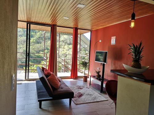 蒙泰韦尔德哥斯达黎加La Guayaba Monteverde的带沙发和大窗户的客厅
