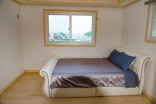 巨济巨济市蓝莓度假屋的窗户客房内的一张床位