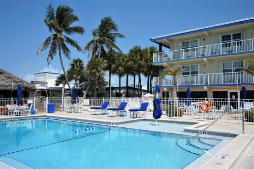 马拉松古伦斯海滨度假酒店的一个带蓝色椅子的游泳池和一间酒店