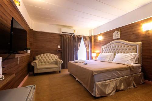 曼谷Infinite Hotel的一间卧室配有一张大床和一把椅子