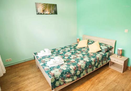 迪南Voisins du kayak的一间卧室配有一张带绿色花卉床罩的床。
