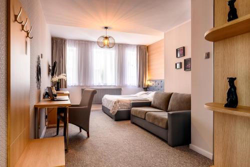 莫龙格Tailor Hotel Sport & Conference的酒店客房,配有床和沙发