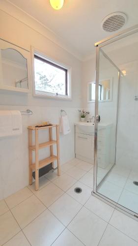 Rosebrook卡达尔小屋的带淋浴和盥洗盆的白色浴室