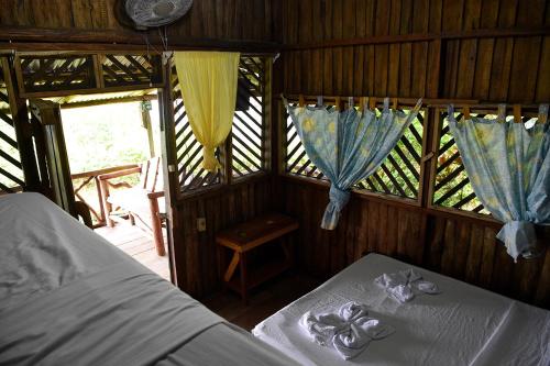 德雷克Bella Vista Corcovado的一间卧室设有两张床,窗户配有窗帘