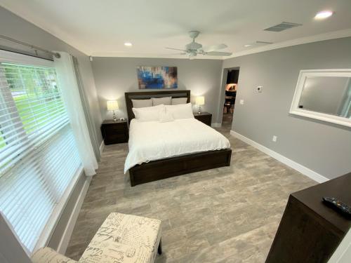 奥兰多Mickeys Pearl - Phenomenal 7BR with 4 Master Suites Privacy Pool & Hot Tub Gas BBQ - 2 miles to Disney的一间卧室设有一张床和一个大窗户