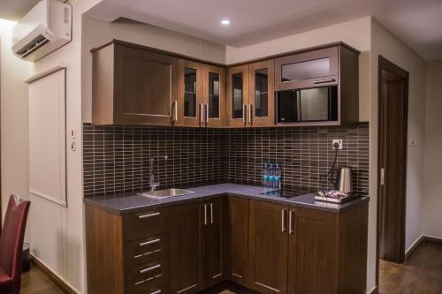 布赖代Al Aryam Serviced Aparthotel的一个带木制橱柜和水槽的厨房