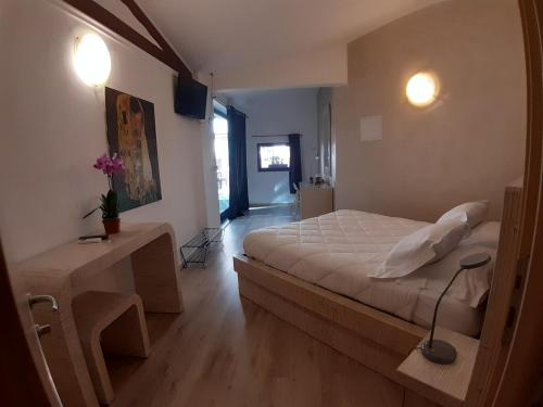 圣雷莫Locanda Sapori的一间卧室配有一张床和一张带台灯的桌子