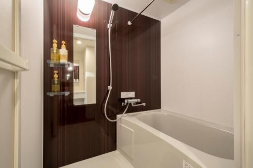 东京Eisei Stay的带浴缸和镜子的浴室