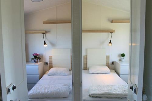 维辛瑟Visingsö Villavagnar的卧室配有2张双层床和白色床单