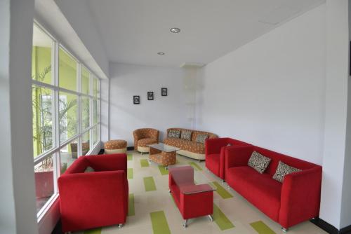 TanjungjohorT-ONE HOTEL的客厅配有红色的沙发和桌子