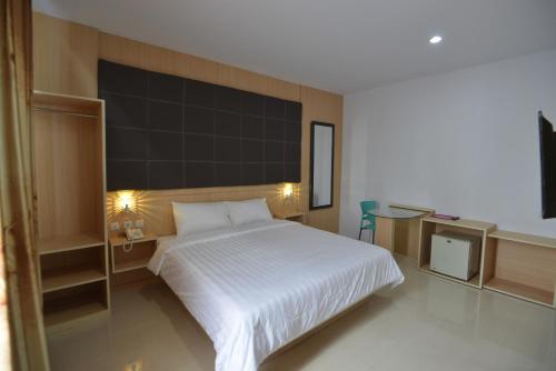 TanjungjohorT-ONE HOTEL的卧室配有一张白色的床和黑色的墙壁