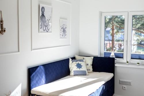 波德贝Apartament 19B Blue Marine Poddąbie的窗户房间里一张蓝色长椅