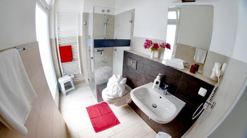 蒂门多弗施特兰德Aura Hotel的白色的浴室设有水槽和淋浴。