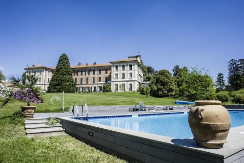 瓦瑞诺博吉博尔基别墅酒店的一座大房子,前面设有一个大型游泳池