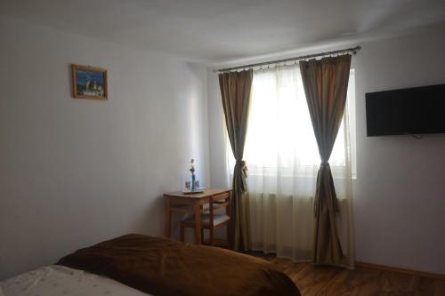 锡纳亚维拉皮蒂酒店的一间卧室配有一张床,窗户配有书桌