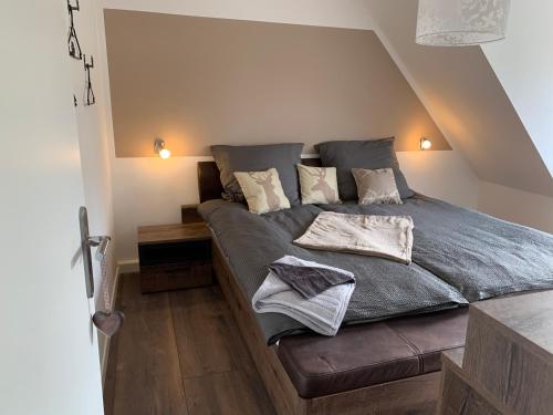 圣安德里斯伯格Harzstübl25的卧室配有一张带灰色床单和枕头的床。