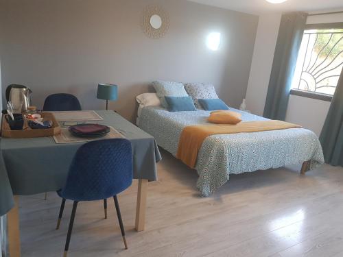 YssingeauxChatimbarbe的卧室配有两张床、一张桌子和一张桌子以及椅子。