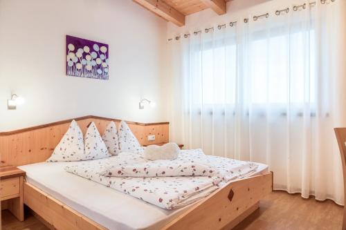 圣马蒂诺Hofschenke Pfeiftal - Heuduft的一间卧室设有一张大床和一个窗户。