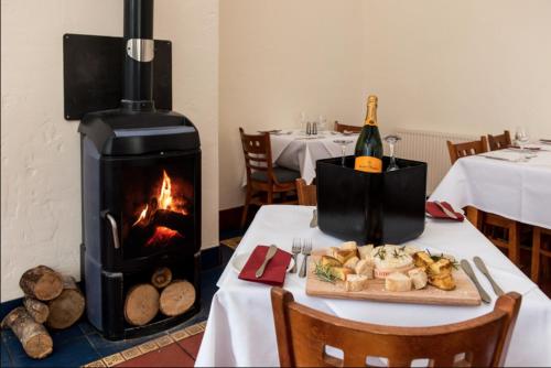 康福斯12 Borwick Lakes by Waterside Holiday Lodges的一张桌子,一张桌子,一个壁炉和一盘食物