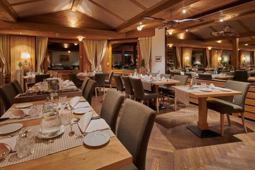 翁根Hotel Alpenrose Wengen - bringing together tradition and modern comfort的餐厅内带桌椅的用餐室