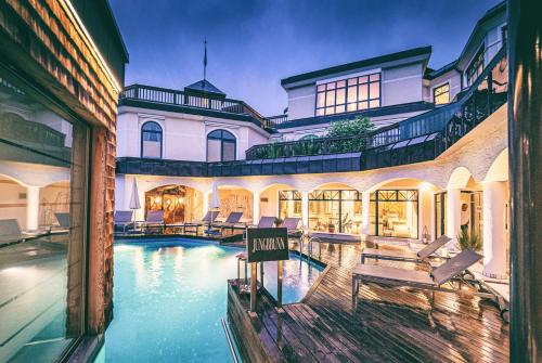霍赫克尼希山麓丁滕优泊古森艾姆度假酒店的一座大房子,前面设有一个游泳池
