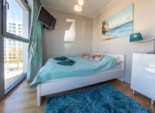 米兹多洛杰Horyzont by Baltic Home的一间卧室设有一张床、一台电视和一个窗口。