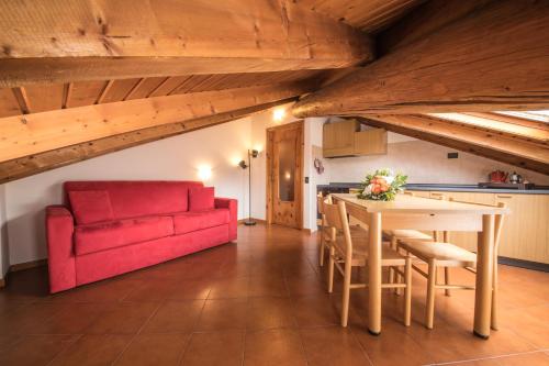 博尔米奥Chalet Felse的客厅配有桌子和红色沙发