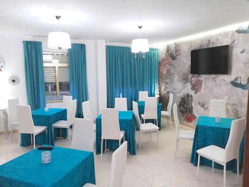 桑亨霍A Casa De Amparo的用餐室配有蓝色桌子和白色椅子